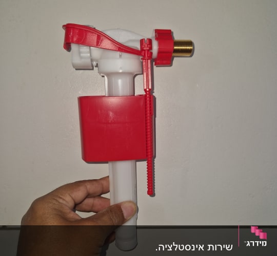 שסתום פלסטיק אדום ולבן על קיר